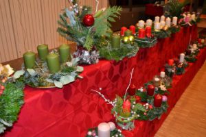 Selbstgebastelte Adventskränze und -gestecke stehen zum Verkauf bereit.